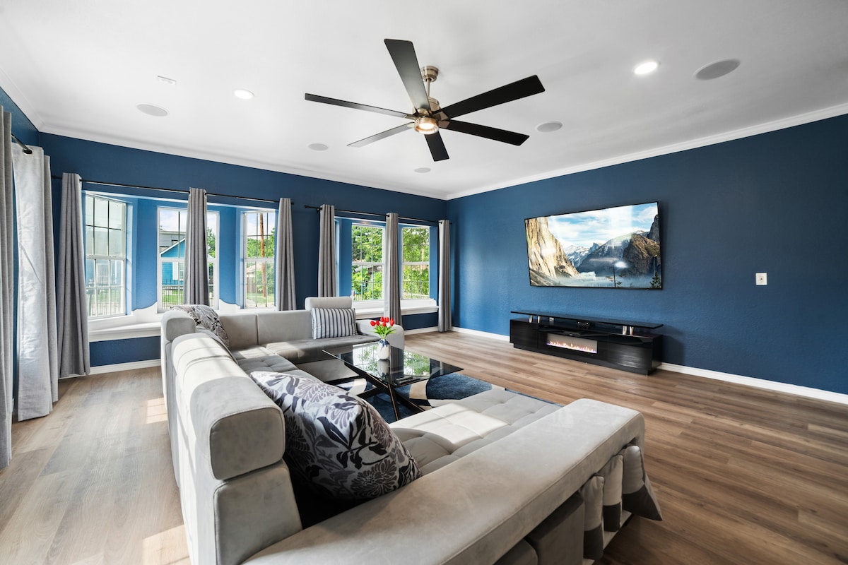 Sala de estar con televisor Samsung 4K de 85 pulgadas y sonido envolvente Dolby Atmos