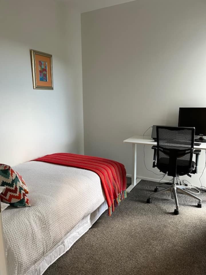 Se trata de una cama tamaño king individual para un adulto y tiene calidad extraíble para un segundo niño.
La habitación funciona como una estación de trabajo lejos del hogar con escritorio de pie y silla de oficina de calidad.  Wifi con dos adultos en Teams y TV a la hora del sam.