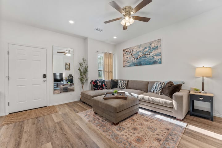 Obývacia izba s novou sekčnou pohovkou, 58-palcovou televíziou Hisense 4K UHD Roku, orientálnou maľbou a zatemňovacími závesmi. Ideálne na oddych alebo streamovanie obľúbených relácií v útulnom súkromnom prostredí.