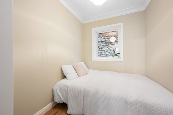 Уютна малка спалня с изглед към тих заден двор.