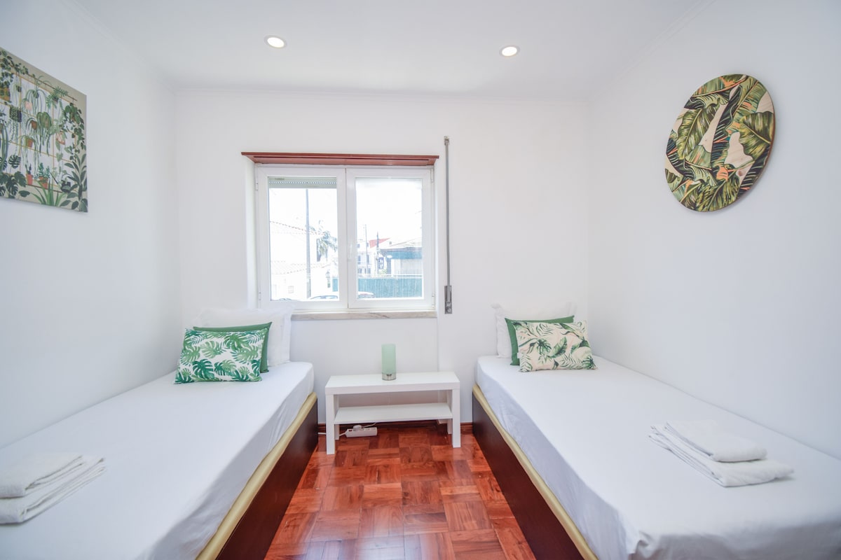 Соба со два единечни кревета и декорација со тропска тематика, вклучувајќи декоративни перничиња и слики на ѕидовите. Помеѓу двата кревета има ноќна масичка и мала ламба. Има тоалет.