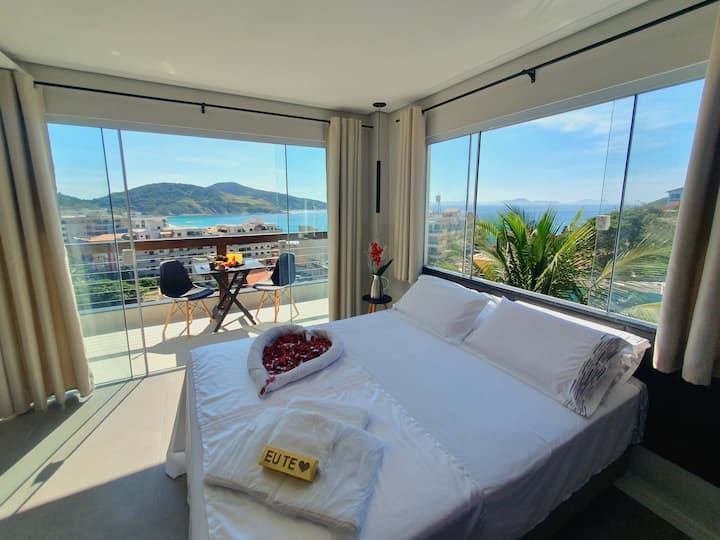 Quarto com ampla janela e porta para a varanda com vista panorâmica para o oceano e o bairro da Prainha em Arraial do Cabo com cama de Casal e Beliche. (Decoração mediante solicitação prévia podendo gerar custos adicionais / Alimentos ilustrativos).