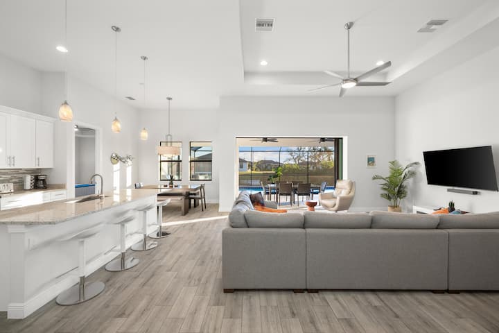 Uitgestrekt uitzicht vanaf de hoofdingang naar de keuken en de woonkamer naar het oversized zwembad.