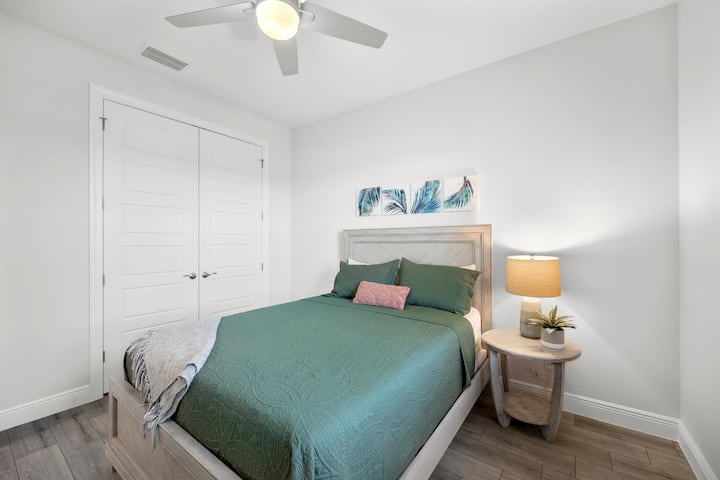 Queensize slaapkamer met dressoir, kast met kledinghangers.