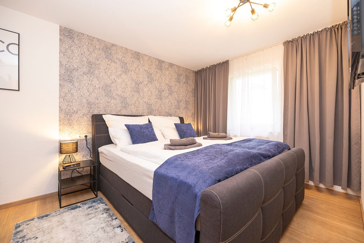 غرفة نوم مع فراش، والعديد من الوسائد، وساعة مع وظيفة الاستيقاظ وخيار الشحن التعريفي للهاتف الخلوي، وتلفزيون بشاشة مسطحة مع تلفزيون وايبو ونيتفليكس، ورف ملابس مع شماعات