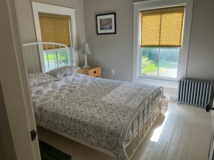 חדר שינה שטוף שמש בקומה השנייה עם מיטת קווין סייז