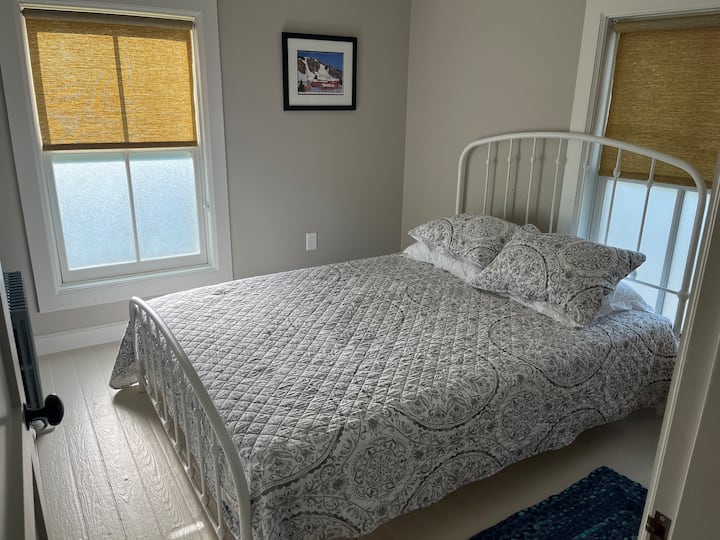 חדר שינה שטוף שמש בקומה השנייה עם מיטת קווין סייז