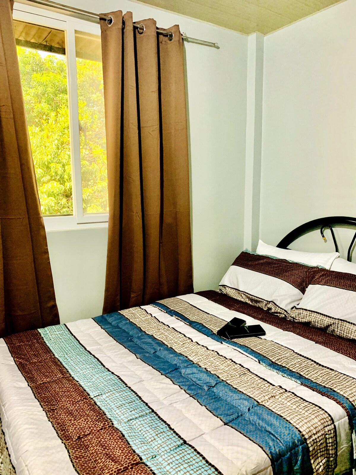 เย็นสบายในห้องนอนที่สองของเรามีเตียงใหญ่ที่อบอุ่นและพัดลมดูดอากาศเพื่อหมุนเวียนเครื่องปรับอากาศที่สดชื่นจากห้องหลัก