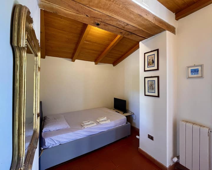 Ერთნახევარი კვადრატული საძინებელი ხის სხვენის ჭერით.