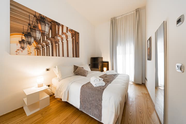 Dormitorio grande con vistas exclusivas a Piazza Maggiore. Los elementos elegantes y de diseño se combinan perfectamente con un entorno histórico, creando un ambiente refinado y cómodo.