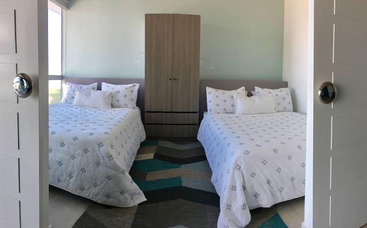 Guest Bedroom with 2 Queen Size beds and a closet.