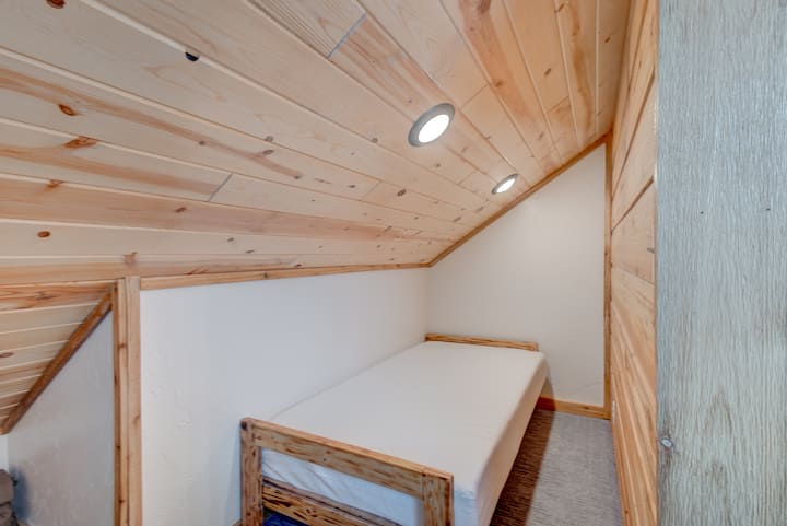 A compact and cozy loft room featuring a built - in single bed, warm wood finishes, and soft recessed lighting. Perfect for kids or extra guests looking for a snug and quiet place to rest.
