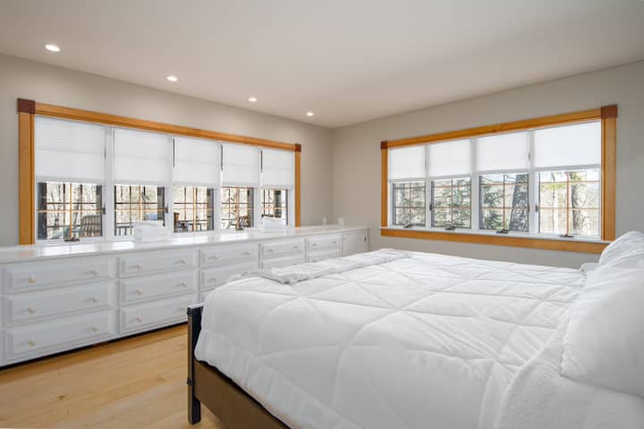 ห้องนอนสว่างพร้อมเตียงคิงไซส์และหน้าต่างบานใหญ่ที่ให้แสงธรรมชาติส่องเข้ามา