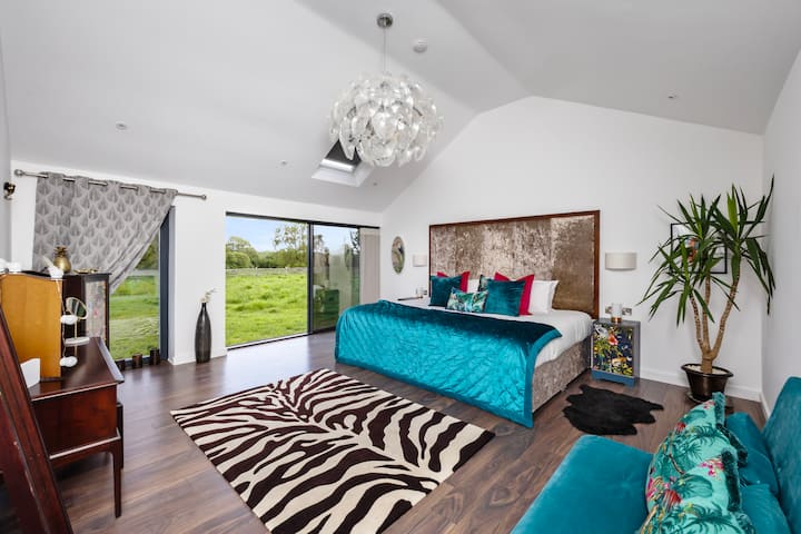 This stunning, glam rock character master bedroom provides a luxurious bedroom with two adjoining double beds ( Super King ) and an additional double sofa bed with sliding doors that open onto stunning countryside views, and remote controlled velux  