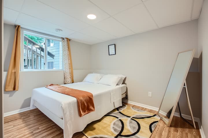 Udobna spavaća soba s prozorom i ogledalom.