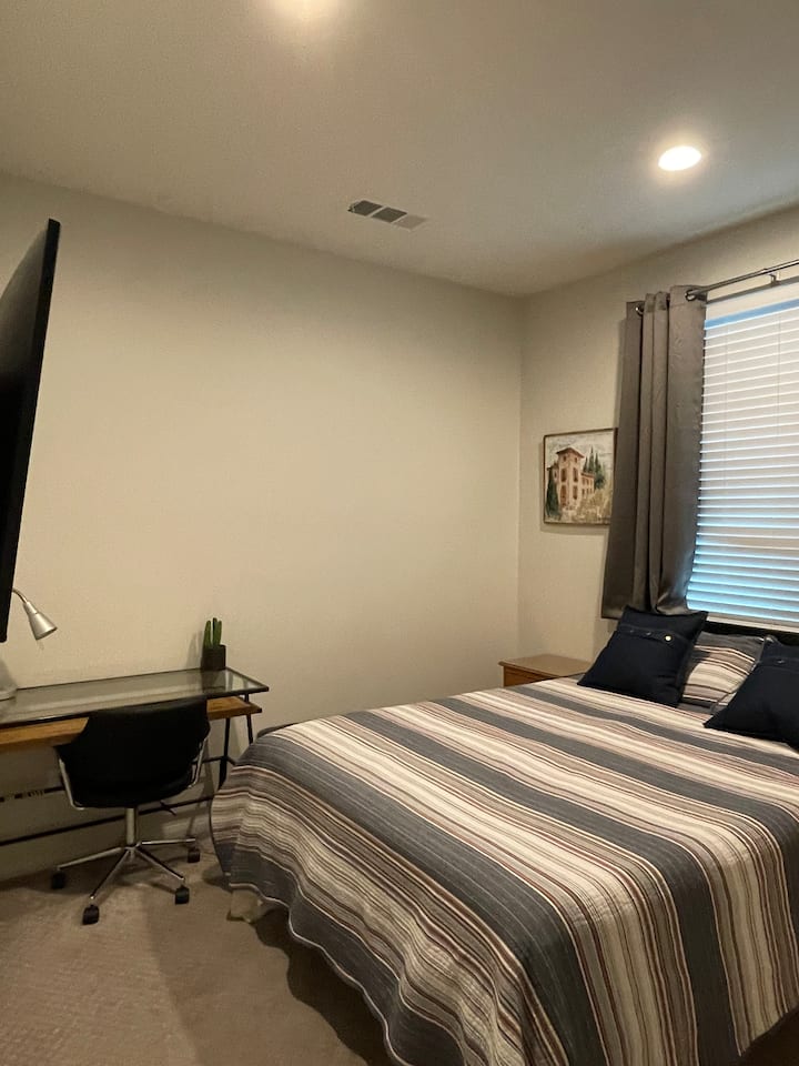 Dhomë gjumi në katin e poshtëm me një banjë korridori që ndodhet jashtë dhomës së gjumit, me një krevat të rehatshëm Casper me përmasa "queen" dhe një tavolinë në hapësirën e dedikuar të punës në dhomë 