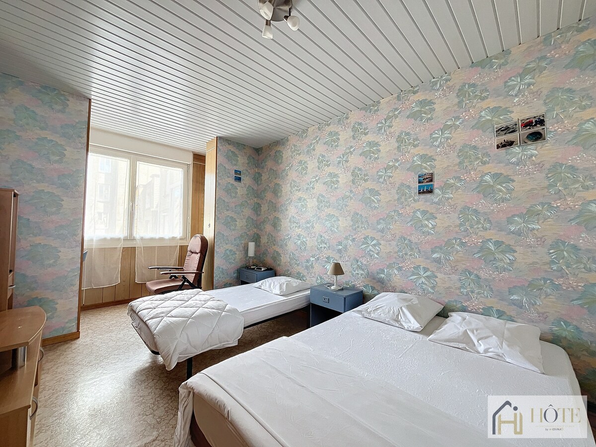 Dhomë e ndritshme dhe e qetë me pasqyrë me gjatësi të plotë dhe dekor të bardhë qetësues — vendi i përkryer për të pushuar dhe për t 'u rigjeneruar.