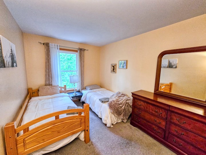 Two twin beds in this bedroom and dresser with large mirror. Located on 2nd floor
