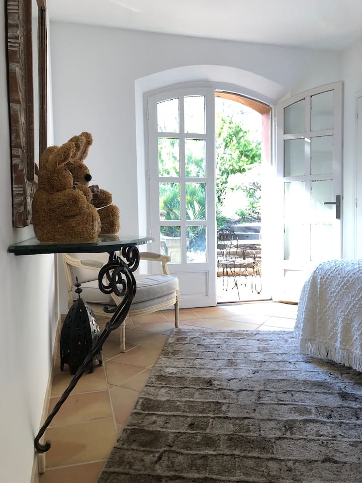 Espace nuit comprenant beau fauteuil, lanterne fer forgé, grand tapis, nbrx éclairages indirects & console 1/2 lune verre/fer forgé sur laquelle repose un remarquable miroir reflétant la terrasse végétalisée.