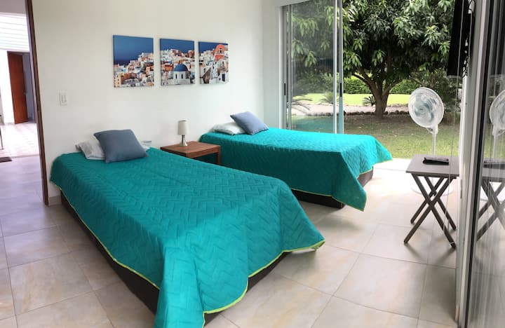 En la habitación 2 tenemos el TV de la casa. La vista del jardín exterior da a nuestros maduros mangos farchil y Tommy, no desestimes tomar algunos mangos para tu desayuno si estamos en cosecha