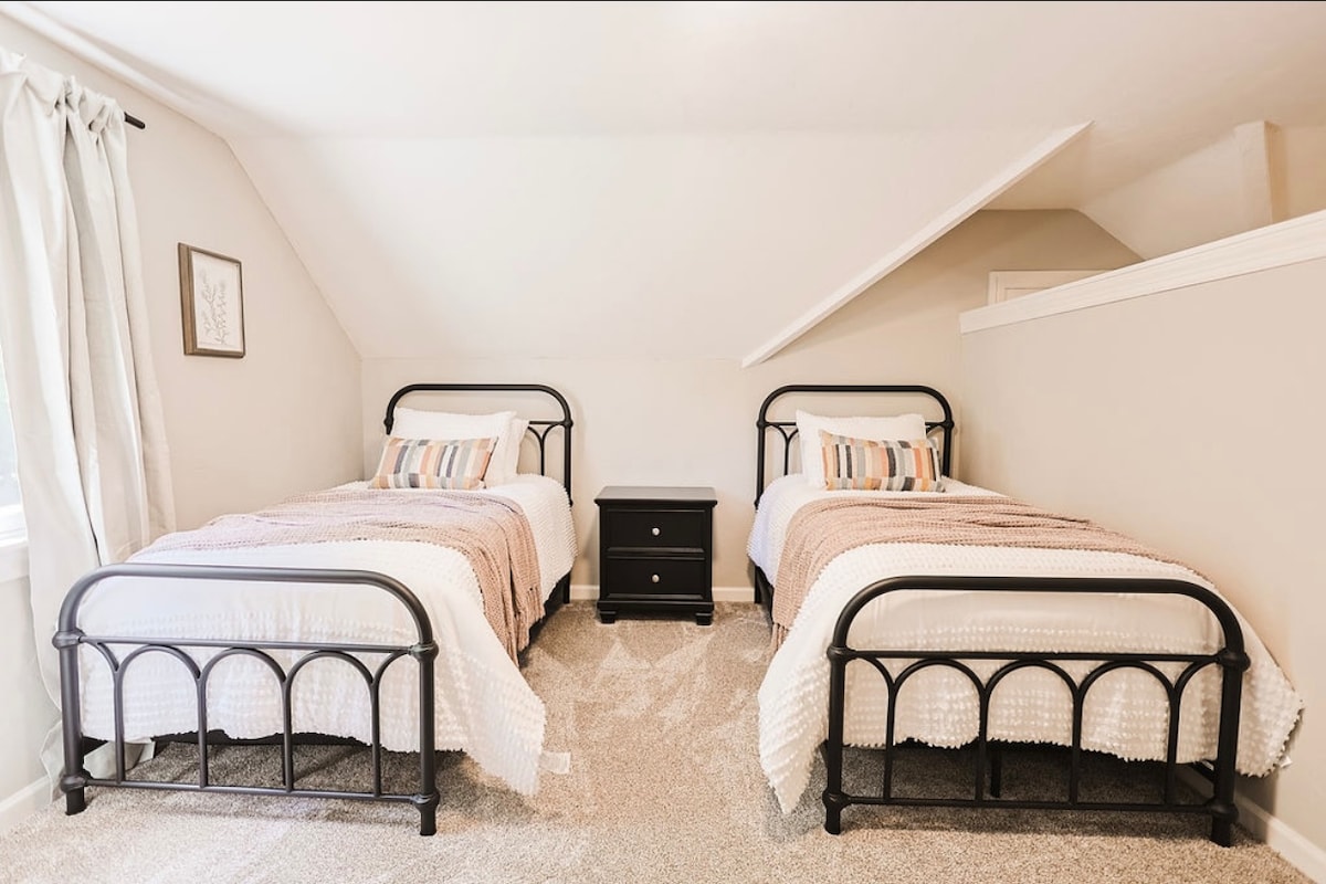 Две единични легла са зад разделена стена в стаята за игри.