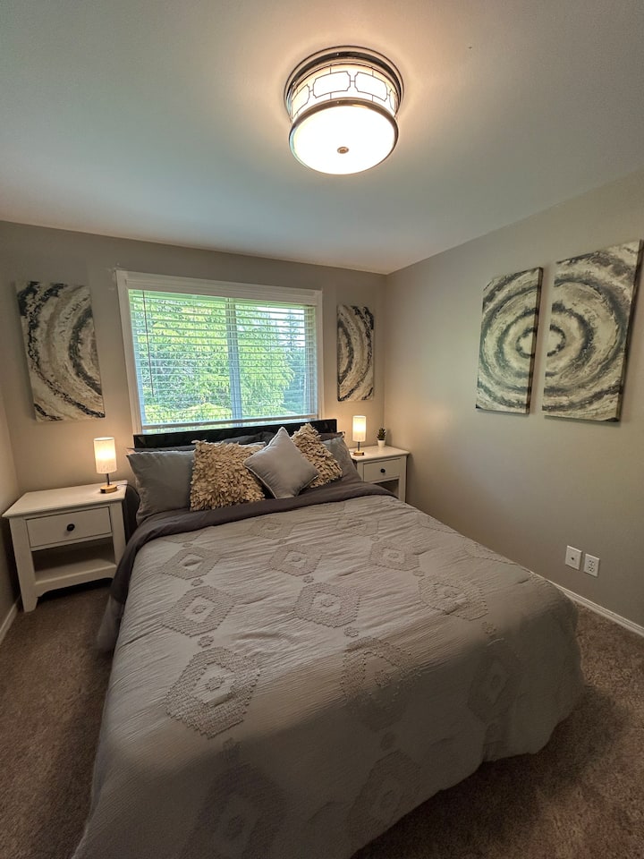 ห้องนอนพร้อมเตียงควีนไซส์ โต๊ะข้างเตียง และตู้เสื้อผ้า