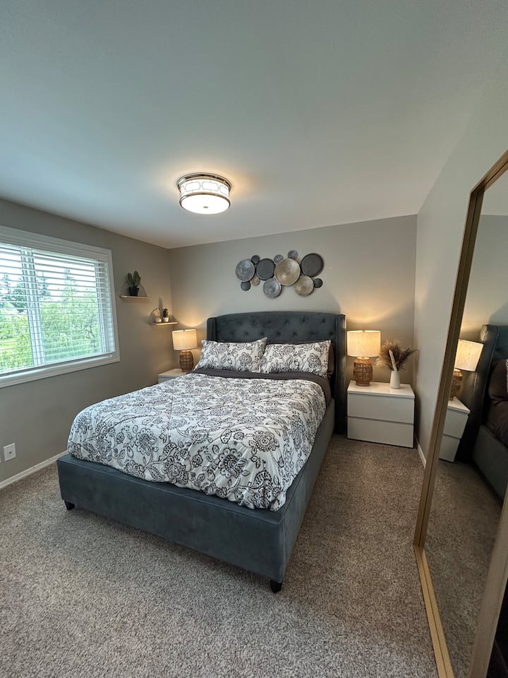 ห้องนอนพร้อมเตียงควีนไซส์ โต๊ะข้างเตียง และตู้เสื้อผ้า