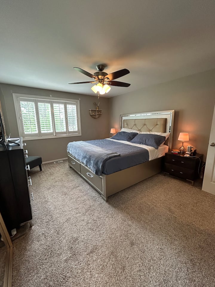 ห้องนอนใหญ่พร้อมเตียงคิงไซส์ ตู้ลิ้นชัก สมาร์ททีวี และโต๊ะข้างเตียง