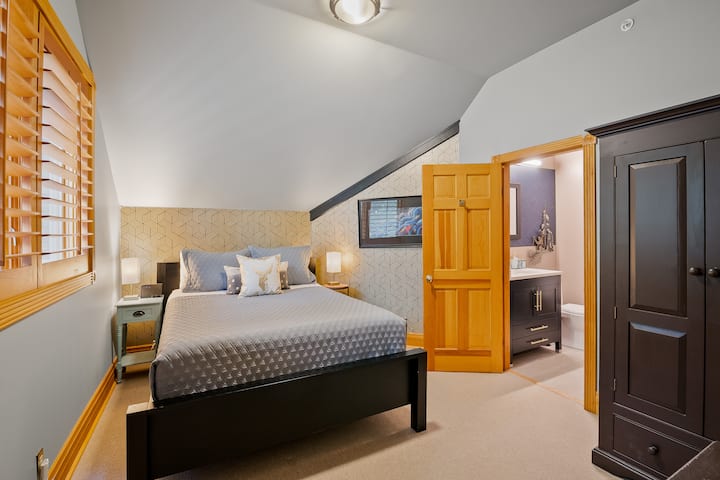 Located at the top of the stairs is this charming queen bedroom with a newly renovated ensuite bathroom with a spacious walk-in shower. 