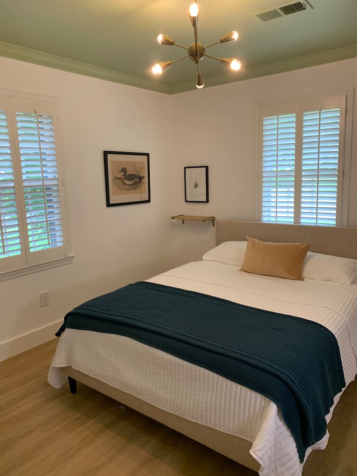 Kitanda cha malkia kilicho na kabati lililo wazi lenye maeneo ya kuhifadhi vitu na kutundika nguo. 