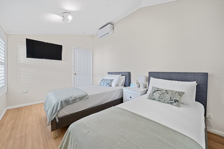 Dormitorio 4 con dos camas individuales con aire acondicionado, armario incorporado y una unidad de TV inteligente, Neflex también está incluido.
