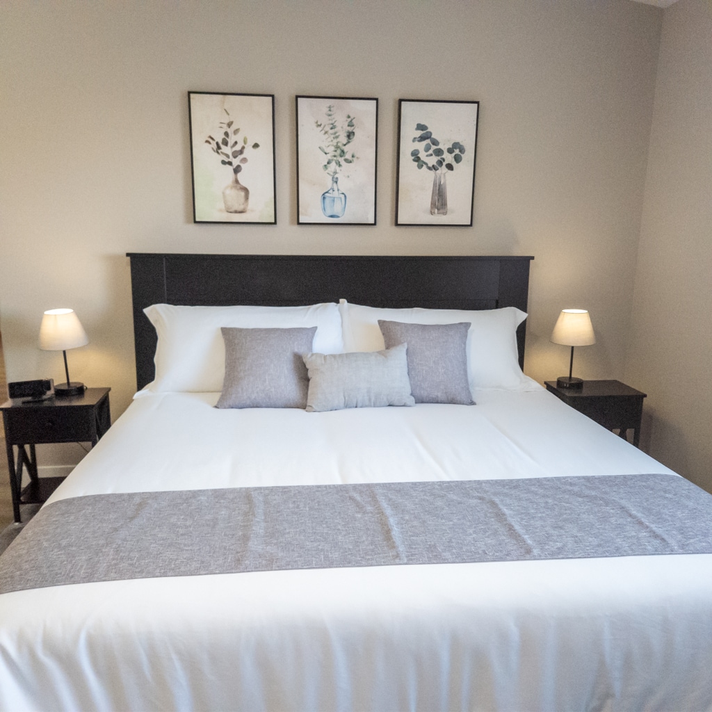 This spacious main bedroom suite has a king-size bed and a calming color scheme. It also has a walk-in closet and a 55" smart TV. This bedroom is a tranquil oasis for relaxation and a perfect escape from the day's hustle and bustle. 