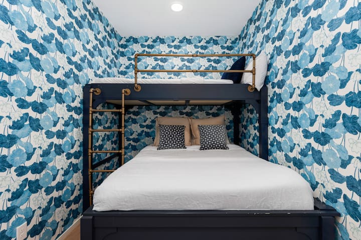 Slaapkamer #2 met een volledig boven queensize stapelbed, een dressoir en een smart-tv.