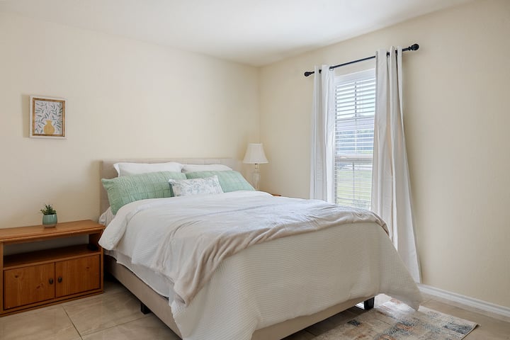 เข้าไปในห้องนอนที่อบอุ่นนี้ซึ่งมีศิลปะบนผนังที่สวยงามโคมไฟข้างเตียงและเตียงนอนสบายๆ