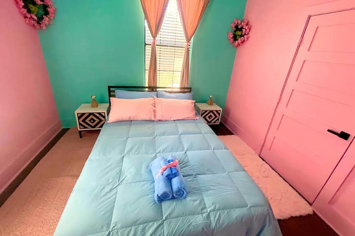 كوتون كاندي كوف: غرفة نوم غريبة الأطوار مع جدران زهرية وزرقاء، وسرير بحجم كوين، وتلفزيون، وخزانة ملابس، ومساحة خزانة، وفراش ناعم، ولمسات زهرية.