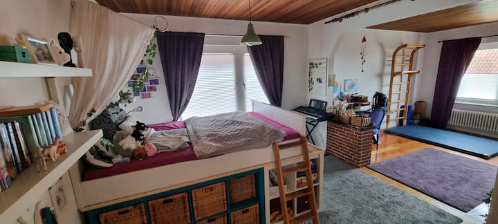 غرفة للنوم والرياضة والحرف اليدوية بسرير مزدوج/أريكة. لوحة مفاتيح وجدار رنين وفراش صالة ألعاب رياضية.