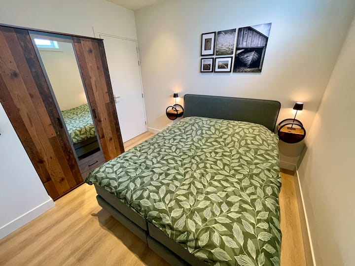 Chumba cha kulala kilicho na kabati kubwa na (kwenye kona) mlango wa bafu.