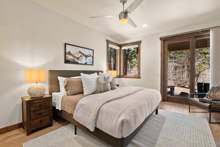 This elegant king bedroom features a private ensuite bath, Smart TV, and direct access to the lower back patio—ideal for morning coffee or a peaceful evening retreat.