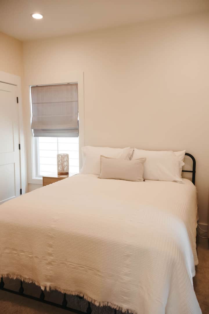 ห้องนอนชั้น 2 ที่อบอุ่นนี้ (ตั้งอยู่ข้างห้องนอน 3 และ 4) มีเตียงนอนที่สะดวกสบายพร้อมผ้าปูที่นอนนุ่มๆ โคมไฟข้างเตียง และแสงธรรมชาติจากหน้าต่าง 