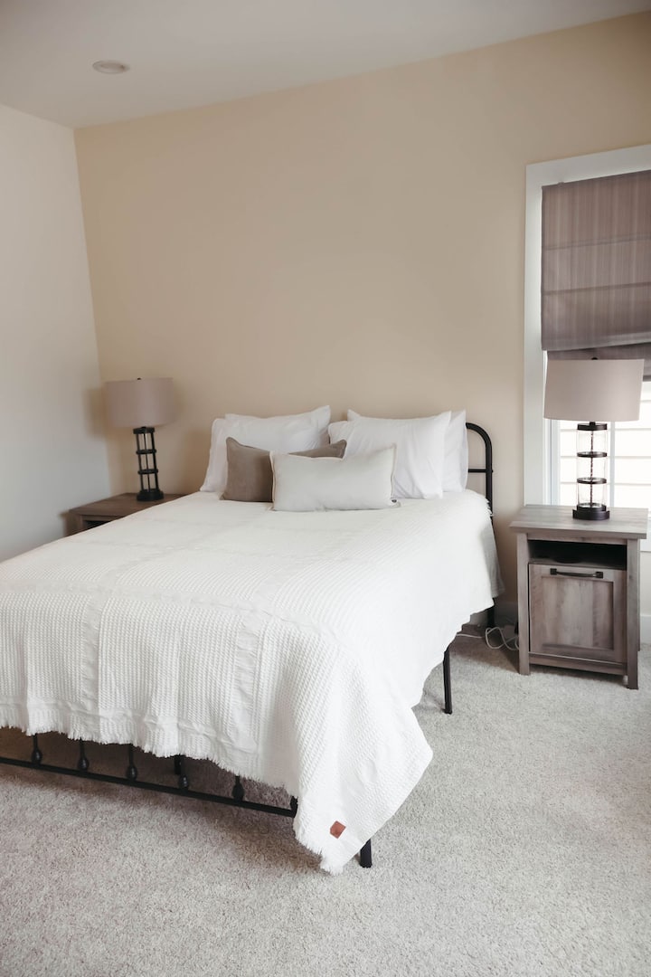 ห้องนอน 3 มีที่พักผ่อนที่อบอุ่นพร้อมเตียงหรู ผ้าปูที่นอนนุ่ม และไฟข้างเตียงเพื่อความสะดวกสบายเพิ่มเติม โทนสีธรรมชาติและแสงธรรมชาติสร้างบรรยากาศที่สงบและผ่อนคลาย เหมาะสำหรับการพักผ่อนและเติมพลังระหว่างเข้าพัก