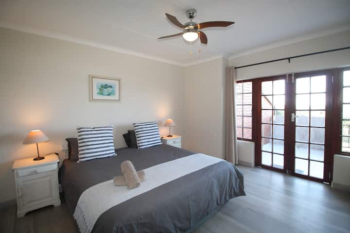 Shelly De Le Mer 5, tento krásny duplex so štyrmi spálňami má ideálnu polohu v komplexe priamo pri pláži v Shelly Beach. Hlavná spálňa na poschodí má manželskú posteľ a otvára sa na malý balkón, kde je krásny výhľad na more.