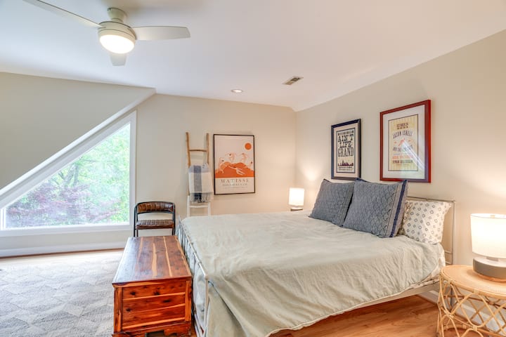 Დიდი ზომის საწოლი, დასაჯდომი სივრცე და სამუშაო მაგიდა ამ სასტუმრო ოთახში.