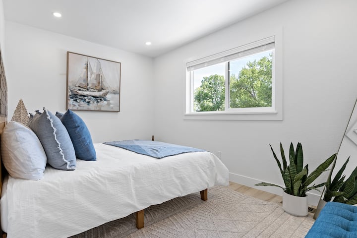 The Seaside Serenity bedroom welcomes ample natural light and features a comfortable queen-size bed.