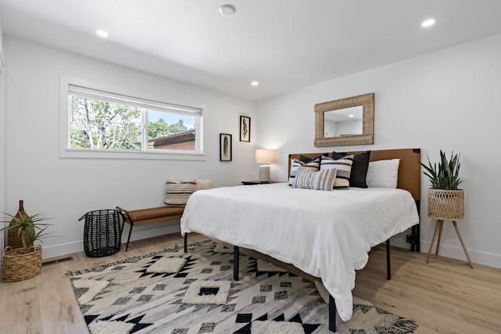 The main level primary bedroom features a king bed and a large window with stunning backyard views.