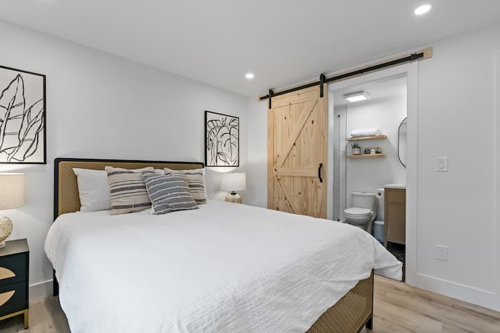 Our Lux Noir primary bedroom features a queen-size bed that comfortably sleeps two people. The room also includes an egress window for basement-level safety.