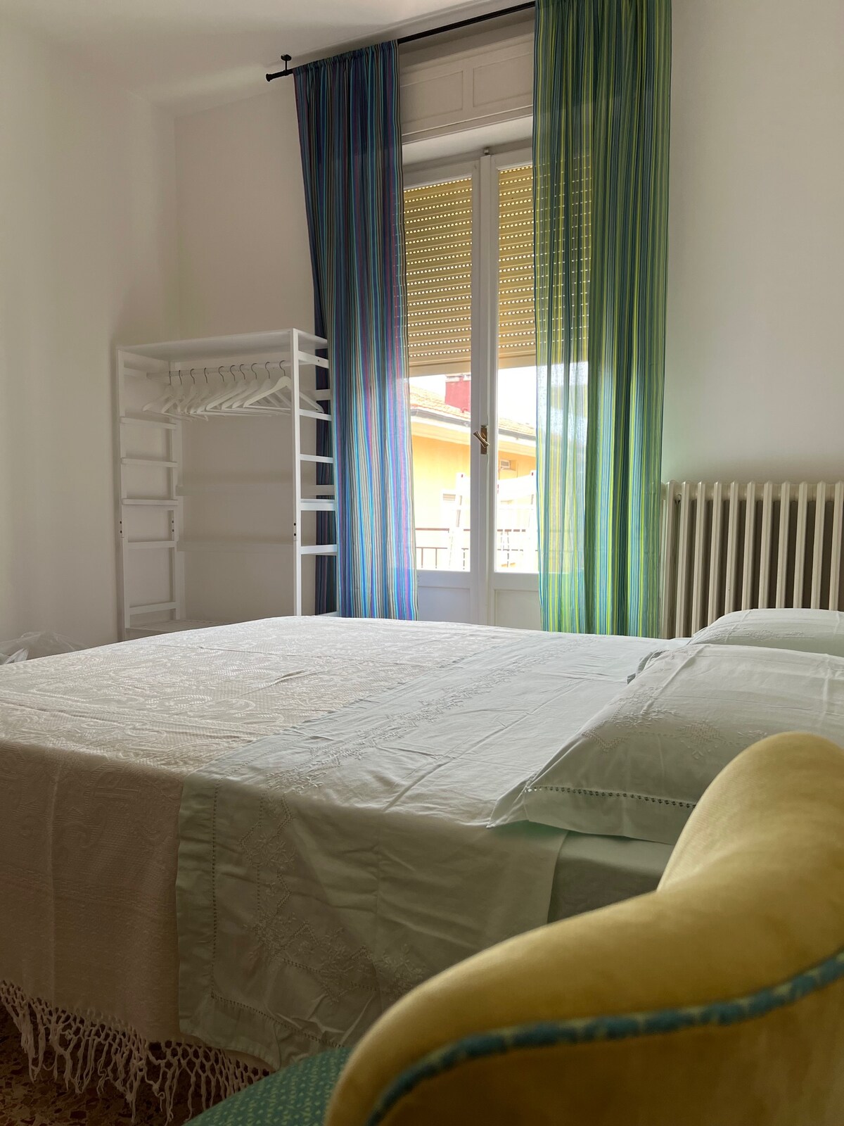 חדר שינה עם מיטה זוגית, כורסאות ושידה