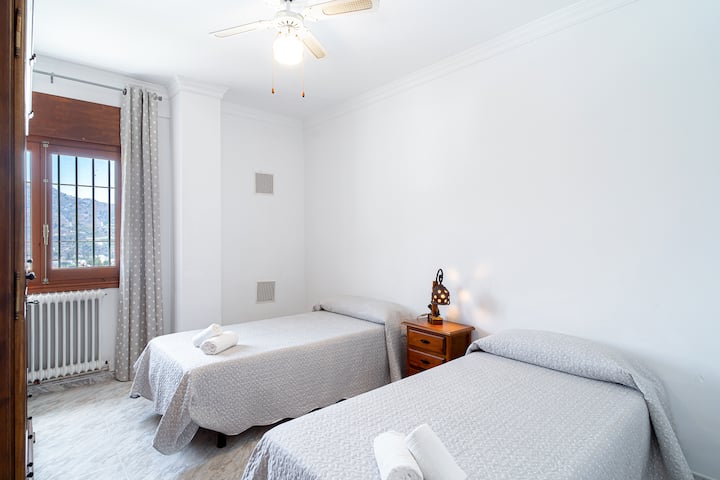 Dormitorio con 2 camas individuales y ventilador de techo.