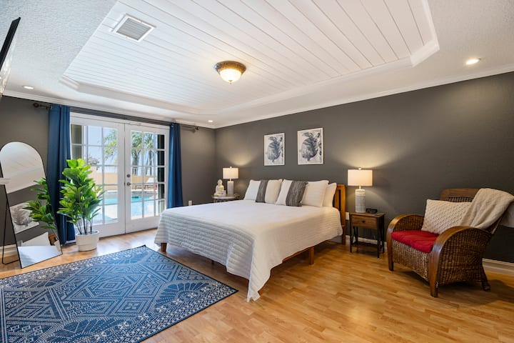 Master bedroom features King size bed, TV, French doors providing direct access to the pool and river views, and en-suite bath.
