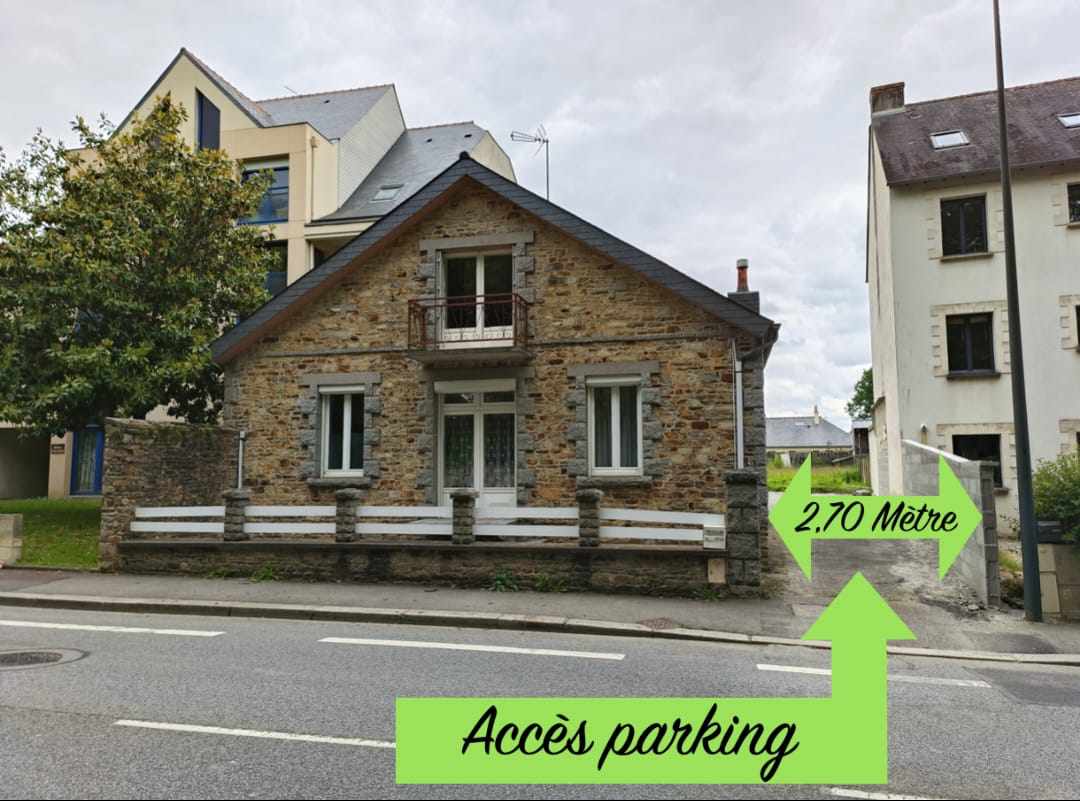 A stone-fronted building is shown, featuring a traditional design with large windows. A sign points to a parking access area measuring 2.70 meters. Surrounding greenery is visible, adding to the setting's overall appeal.