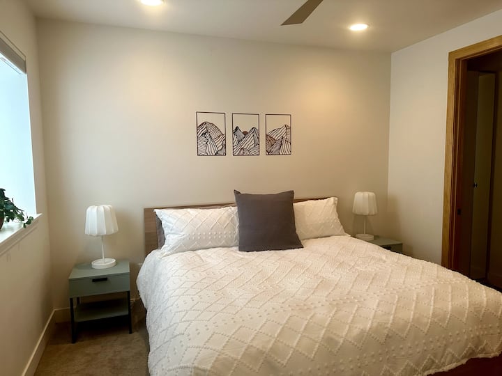 Брачна спална соба на пониско ниво со сопствена бања, телевизор и камин